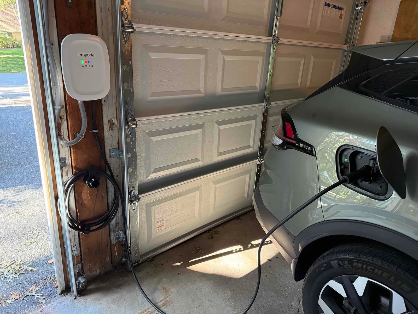 Wall-mounted EV charger in a garage charging an electric vehicle